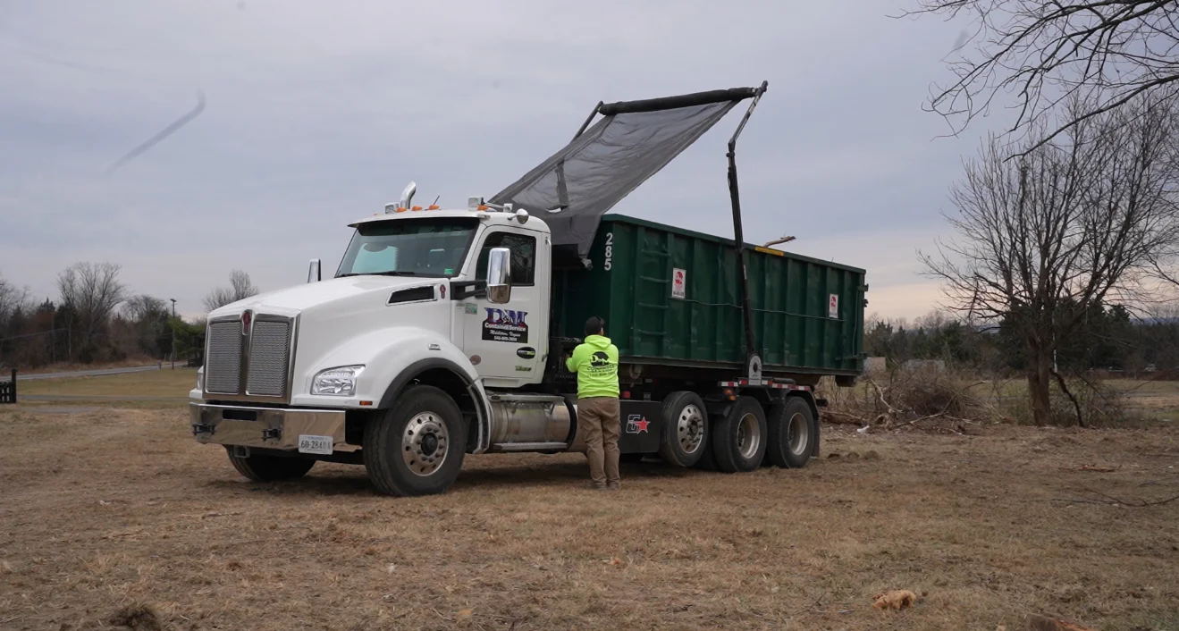 Dumpster rental truck picking up a full roll off container in Winchester VA