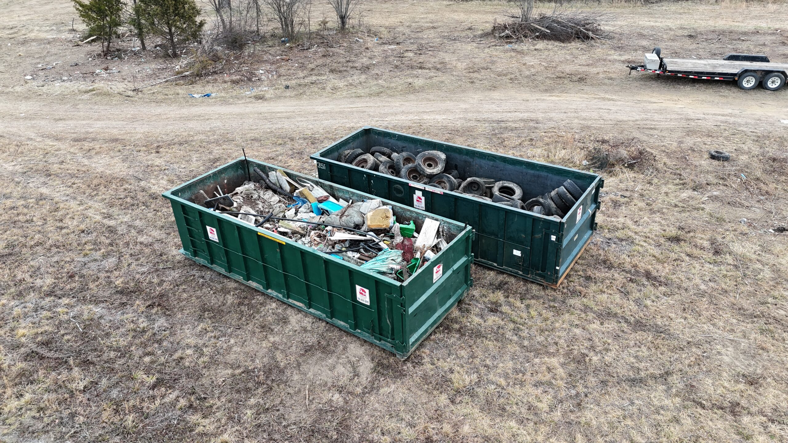 Two roll off dumpsters loaded with debris and scrap tires at a job site near Winchester VA